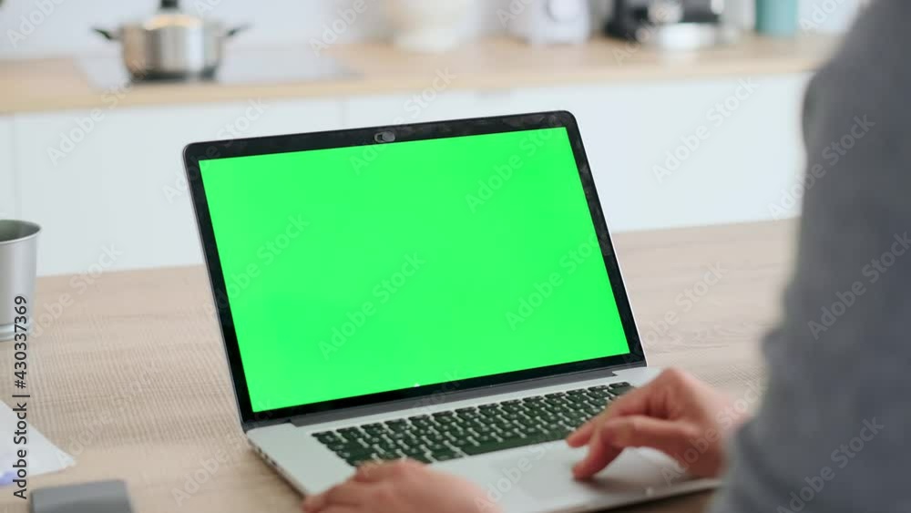 Video of afro business woman using laptop computer with a green screen on monitor in the kitchen at home. Video of afro business woman using laptop computer with a green screen on monitor in the kitchen at home.