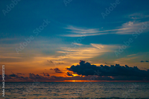 Tropical orange sunset on the beach in Zanzibar. Evening sunny Indian ocean coast.