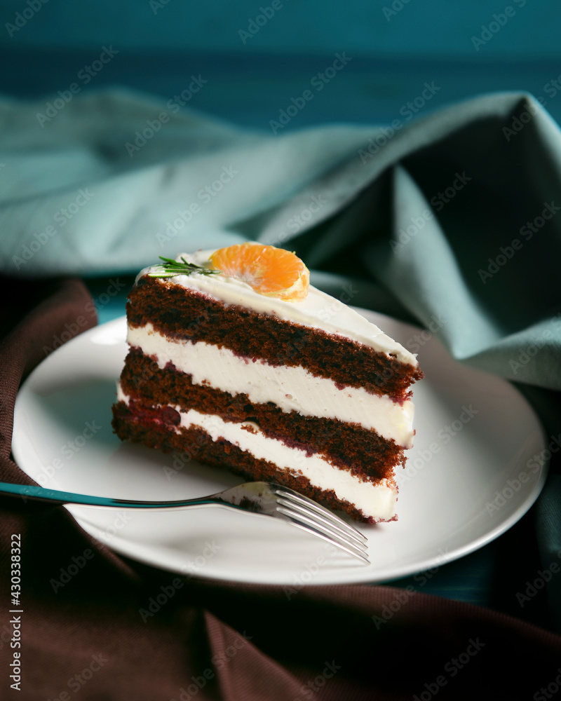 A piece of chocolate cake with vanilla cream. Berries inside and a piece of tangerine on top. A piece of chocolate cake with vanilla cream. Berries inside and a piece of tangerine on top.
