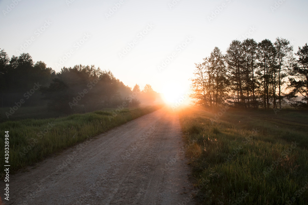 Scenic view to the country road with the fog clad sunrise Scenic view to the country road with the fog clad sunrise