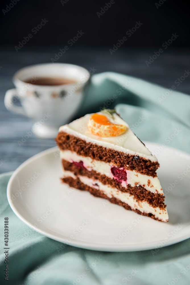 A piece of chocolate cake with vanilla cream. Berries inside and a piece of tangerine on top. A piece of chocolate cake with vanilla cream. Berries inside and a piece of tangerine on top.