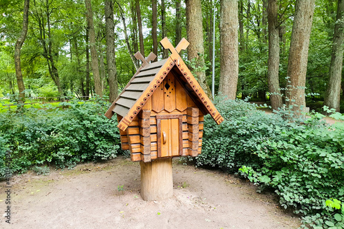 Wooden bird house feeder in garden park with green tree background