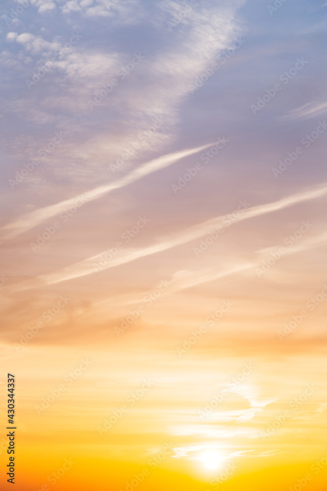 Beautiful bright summer sunset sky, yellow, orange and blue color natural background, vertical picture