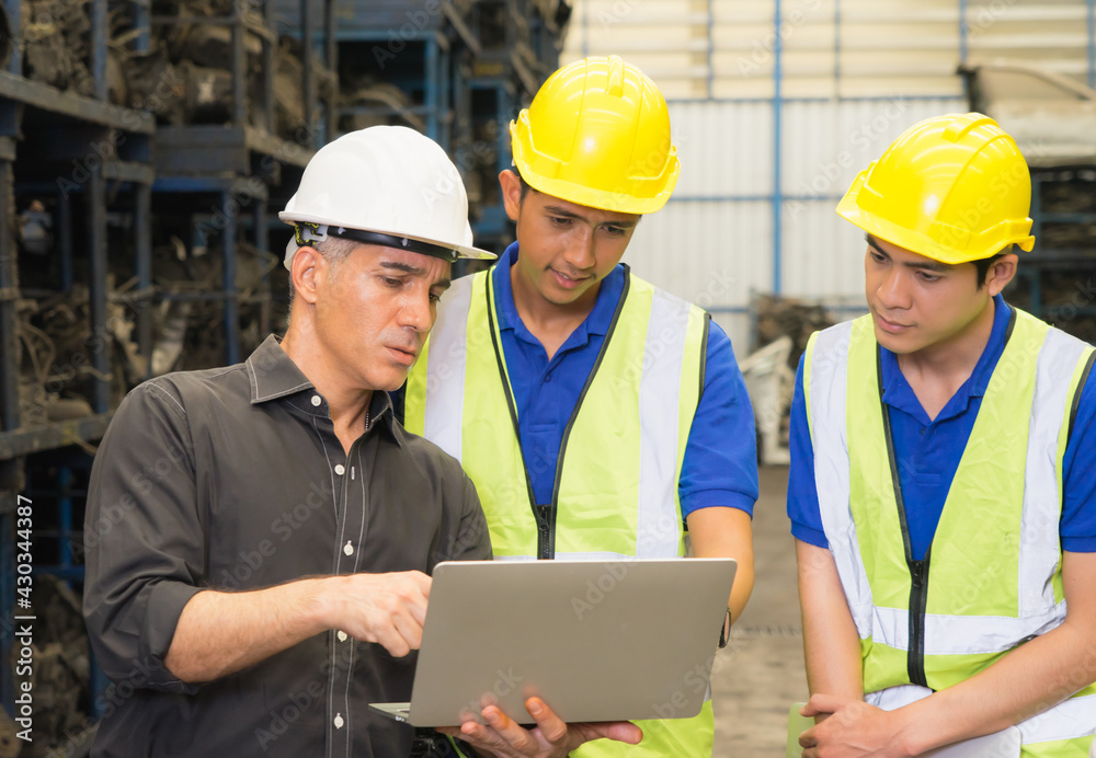 Men work together, diversity of Caucasian manager order two Asian engineer workers in factory-warehouse Men work together, diversity of Caucasian manager order two Asian engineer workers in factory-warehouse