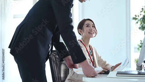 オフィスのデスクで話をする会社員