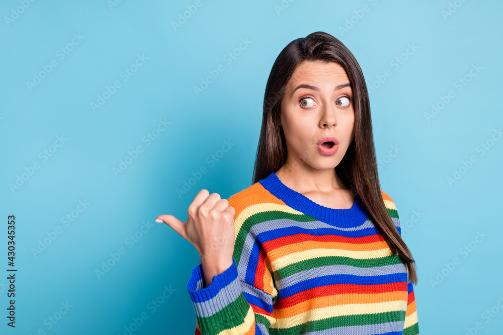 Photo portrait of girl surprised amazed showing thumb copyspace curious opened mouth isolated on vibrant blue color background Photo portrait of girl surprised amazed showing thumb copyspace curious opened mouth isolated on vibrant blue color background
