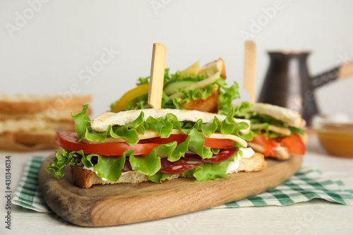 Delicious sandwiches with vegetables and cheese on white table  closeup