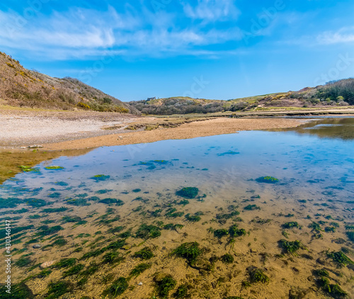 A view up the stream on the beach at Three Cliffs Bay, Gower Peninsula, Swansea, South Wales on a sunny day