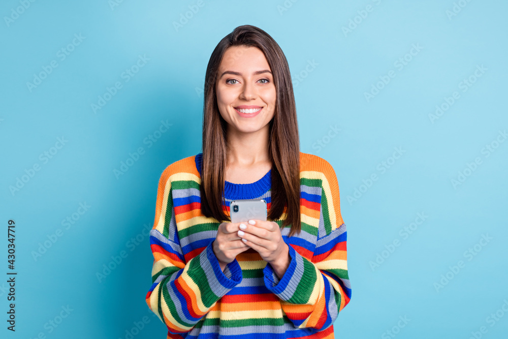 Photo portrait of girl using app on cellphone browsing internet smiling isolated on vivid blue color background Photo portrait of girl using app on cellphone browsing internet smiling isolated on vivid blue color background