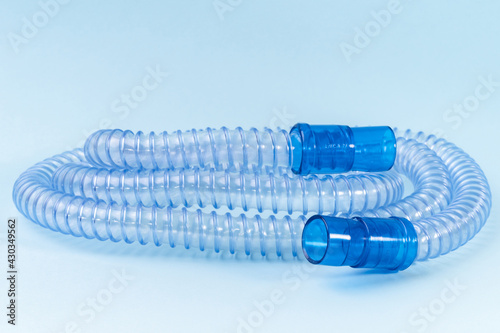 Tubing for CPAP or BIPAP machine with green filter isolated on blue background. Medical equipment photo