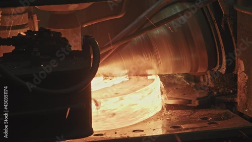Close up of ring rolling machine forging steel rings red from heat and temperature in forging shop