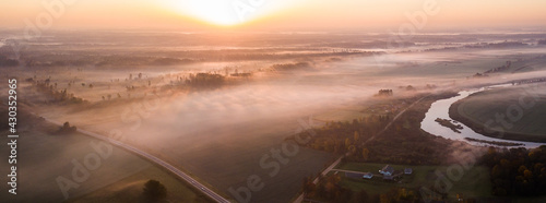 Fototapeta Naklejka Na Ścianę i Meble -  Aerial view of sunrise over the forest and fields, Latvia.