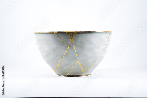 Grey broken pottery restored with Kintsugi, representation of broken heart with pottery. photo