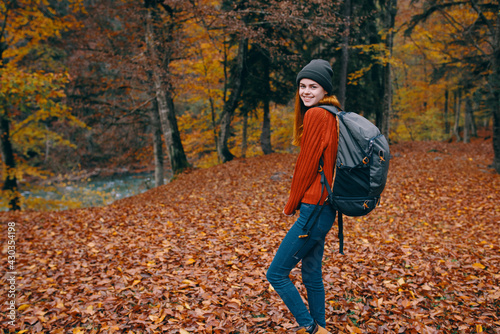 hiking travel woman with backpack on her back and fallen dry leaves nature forest park model