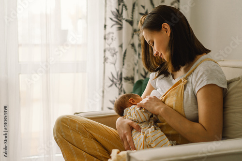Newborn baby boy sucking milk from mothers breast. Portrait of mom and breastfeeding baby. photo