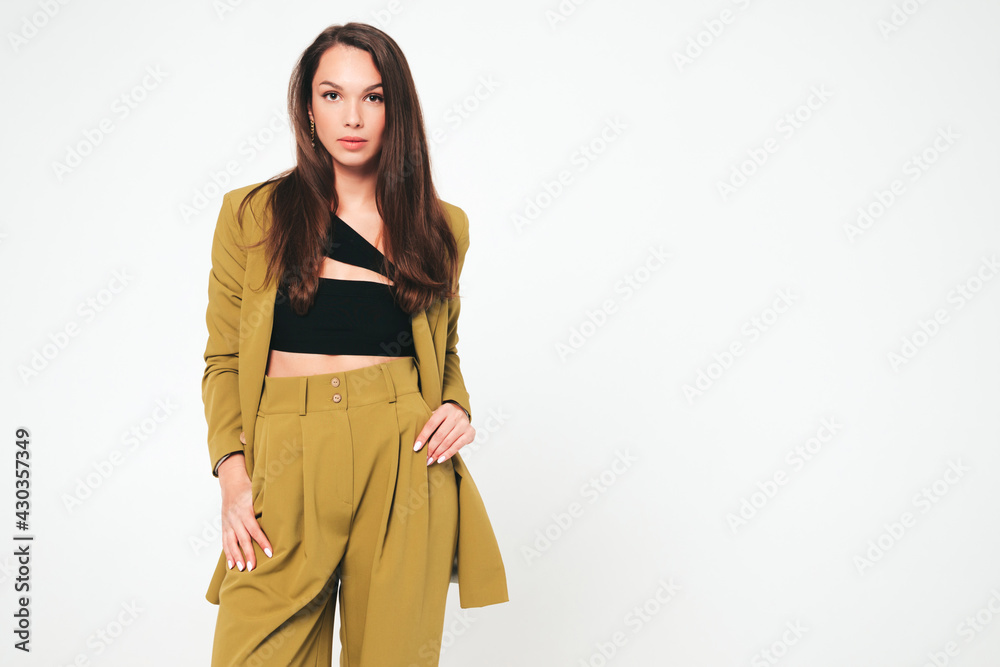 Young beautiful smiling female in trendy summer suit clothes. Sexy carefree woman posing on grey background in studio. Positive model having fun indoors. Cheerful and happy Young beautiful smiling female in trendy summer suit clothes. Sexy carefree woman posing on grey background in studio. Positive model having fun indoors. Cheerful and happy