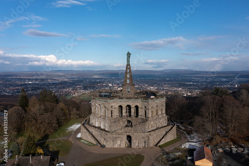Luftaufnahme von forne des gesamten Monumentalbau Herkules mit Blick auf die Stadt Kassel mit blauem Himmel, Hessen, Deutschland