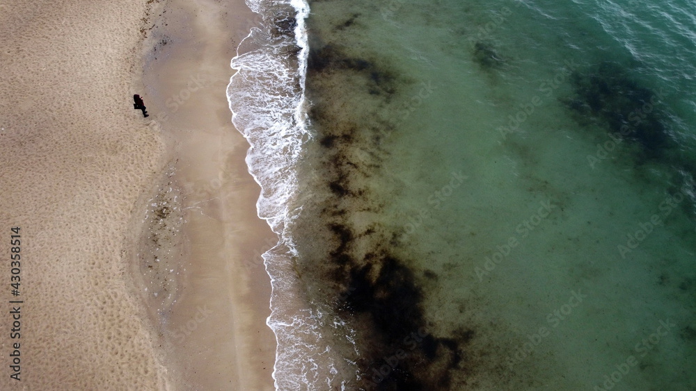 a man stands by the sea, view from a drone
