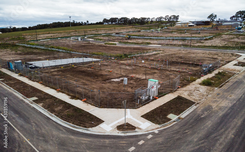 Aerial views on a newly created Australian housing estate. Construction starts on a newly titled block of land, construction fences are up and within months a new house will be built on this site.