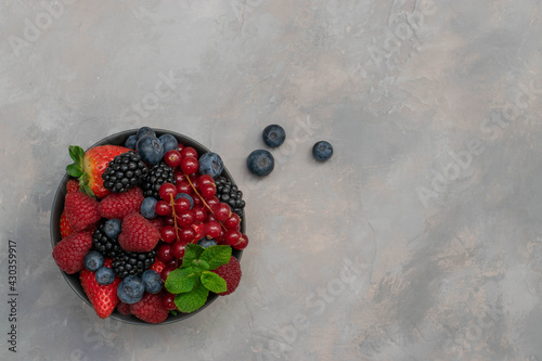 Ripe sweet different berries in bowl. Close up, top view. rvest Concept photo