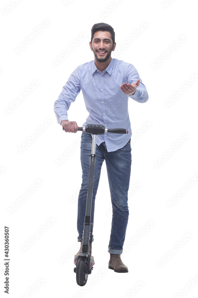 in full growth. happy young man with an electric scooter in full growth. happy young man with an electric scooter