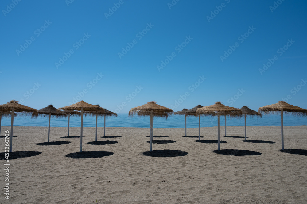playa con sombrillas vacía de personas con cielo azul