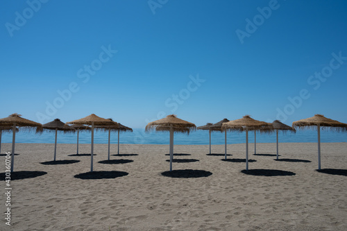 playa con sombrillas vacía de personas con cielo azul © Fredy Torra