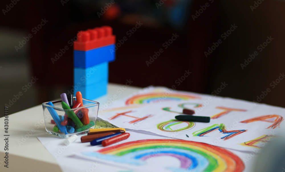 Fototapeta premium A boy of 4-7 years old sits at the table and draws with multi-colored paints. Children's creativity. Children's hobbies. High quality photo