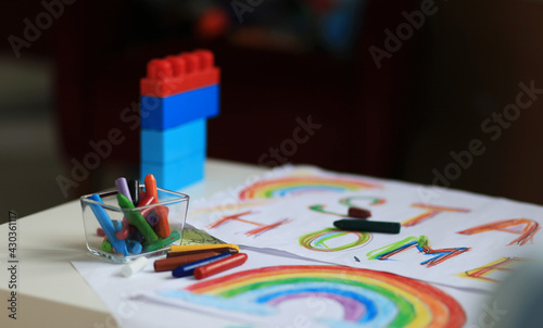 A boy of 4-7 years old sits at the table and draws with multi-colored paints. Children's creativity. Children's hobbies. High quality photo