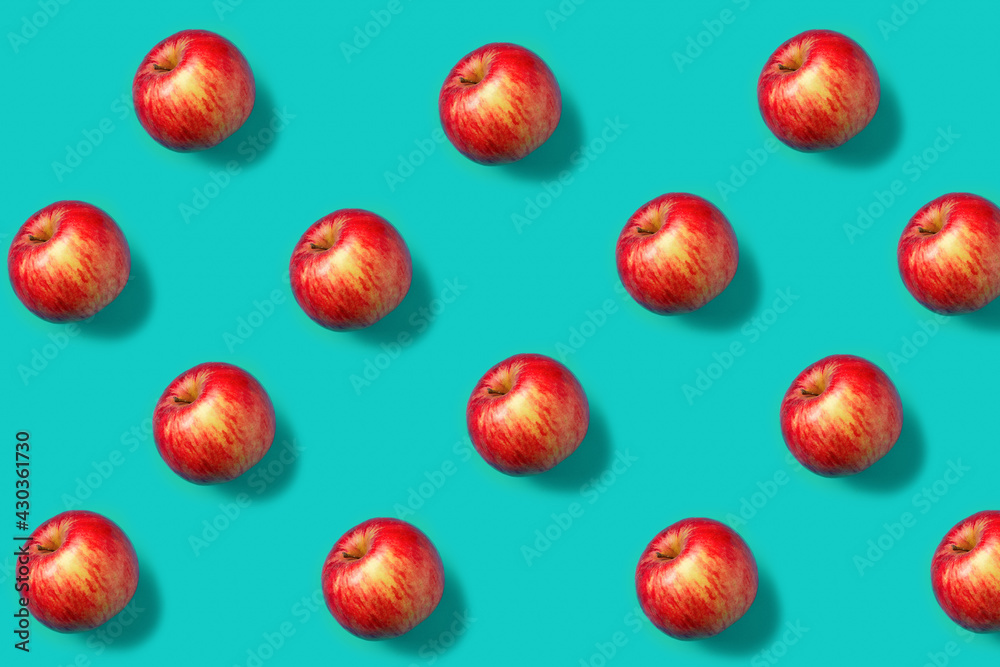 Colorful fruit pattern with fresh red apples on vibrant blue background. Minimal food concept. Vegetarian diet banner or vitamin healthy texture. Flat lay, top view. Colorful fruit pattern with fresh red apples on vibrant blue background. Minimal food concept. Vegetarian diet banner or vitamin healthy texture. Flat lay, top view.