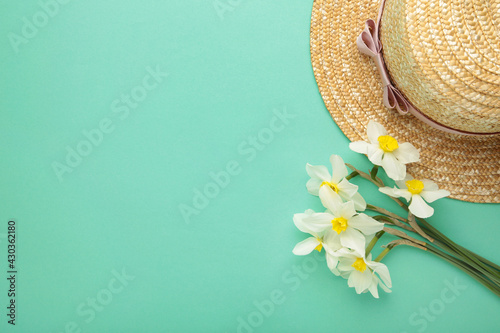 Fototapeta Naklejka Na Ścianę i Meble -  Straw hat with spring flowers on mint background