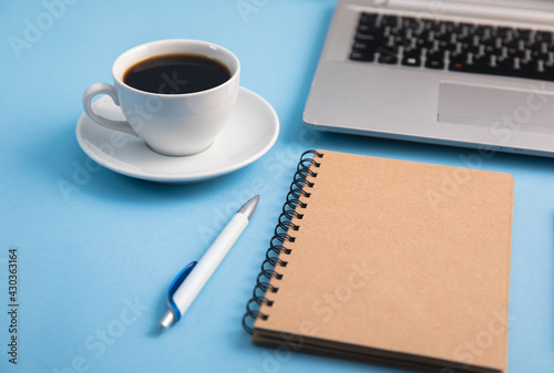 computer with notepad and coffee on table