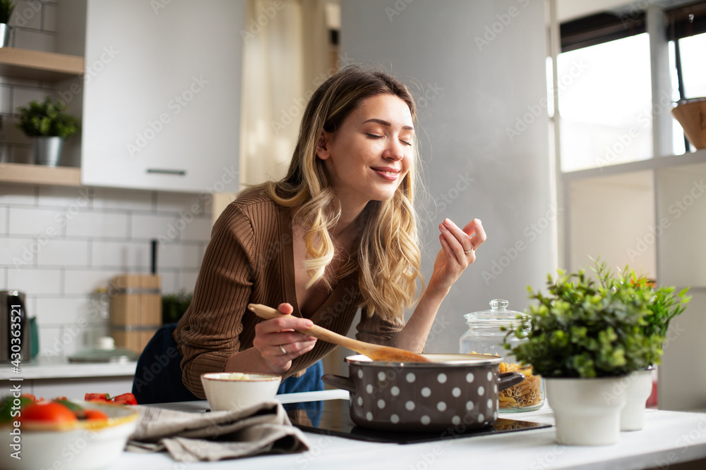 Attractive woman cooking in modern kitchen. Beautiful woman preparing food.. Attractive woman cooking in modern kitchen. Beautiful woman preparing food..