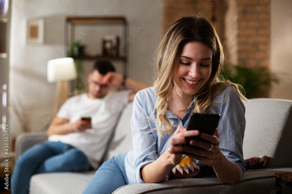 Happy young woman using the phone at home. Excited woman enjoying in the living room.. Happy young woman using the phone at home. Excited woman enjoying in the living room..
