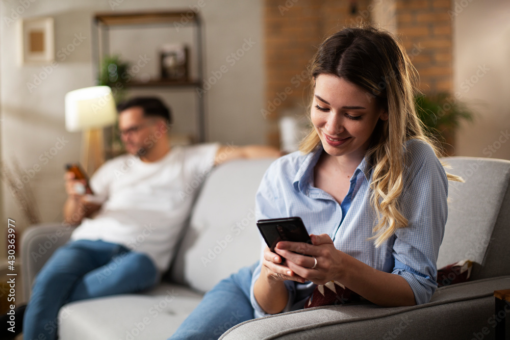 Happy young woman using the phone at home. Excited woman enjoying in the living room.. Happy young woman using the phone at home. Excited woman enjoying in the living room..