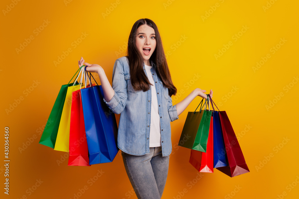 Picture of girl with shopping bags over yellow background