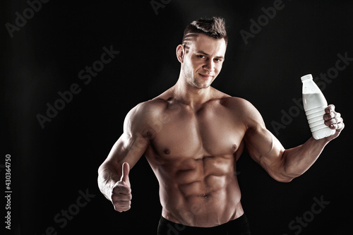 sexy muscular male torso and body of handsome macho man or athlete guy workout or training, holds white thermo mug, bottle or flask with drink on black background