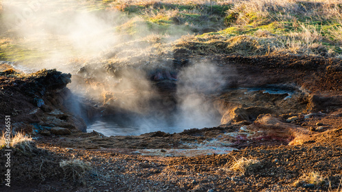 Wasserdampf steigt aus einem brodelnden Schlammloch in einem isländischen Geothermalgebiet