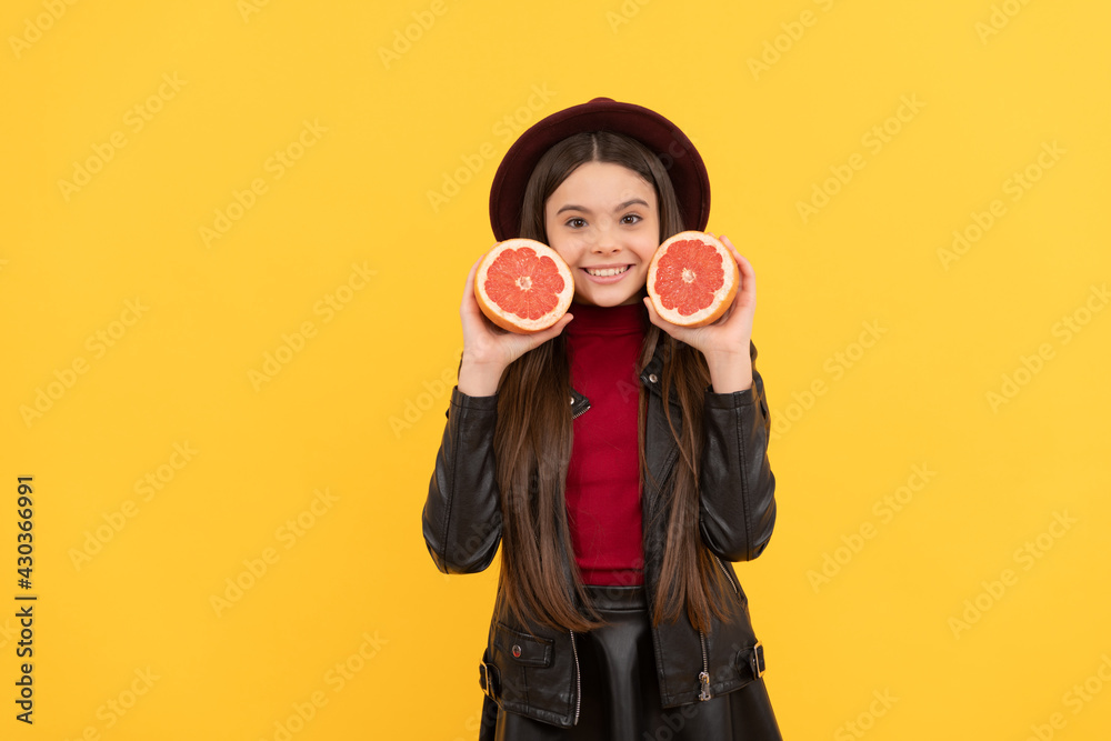 happy teen girl in hat and leather jacket hold cut grapefruit, diet happy teen girl in hat and leather jacket hold cut grapefruit, diet