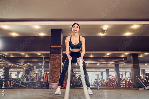 Caucasian fit woman dressed in sportsoutfit posing with battle r photo