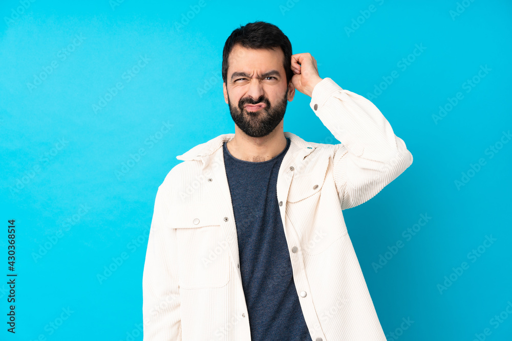 Young handsome man with white corduroy jacket over isolated blue background having doubts Young handsome man with white corduroy jacket over isolated blue background having doubts