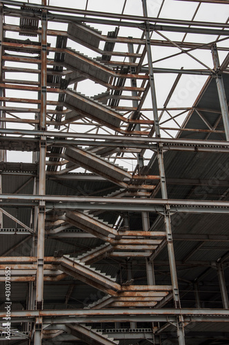 Low angle view of a building under construction with unfinished concrete staircases and construction site safety net which can sustain heavy jerks.