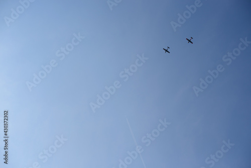 Two historic planes and one modern plane in blue skies