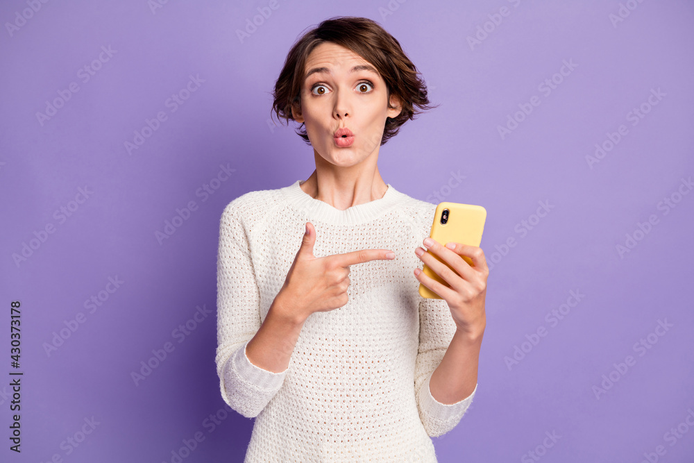 Photo portrait of surprised amazed female student showing finger smartphone whistle isolated on pastel purple color background Photo portrait of surprised amazed female student showing finger smartphone whistle isolated on pastel purple color background