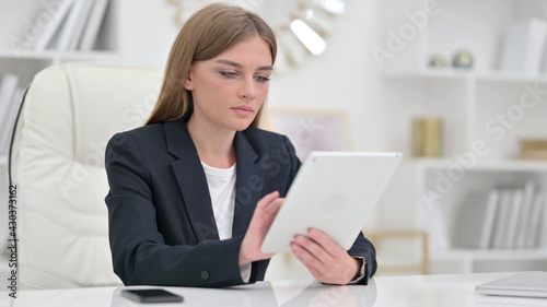 Serious Professional Businesswoman using Tablet in Office 