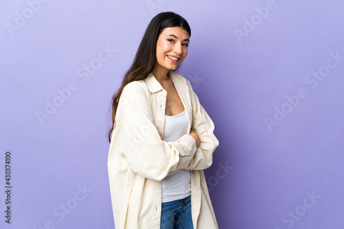 Young brunette woman over isolated purple background looking to the side and smiling