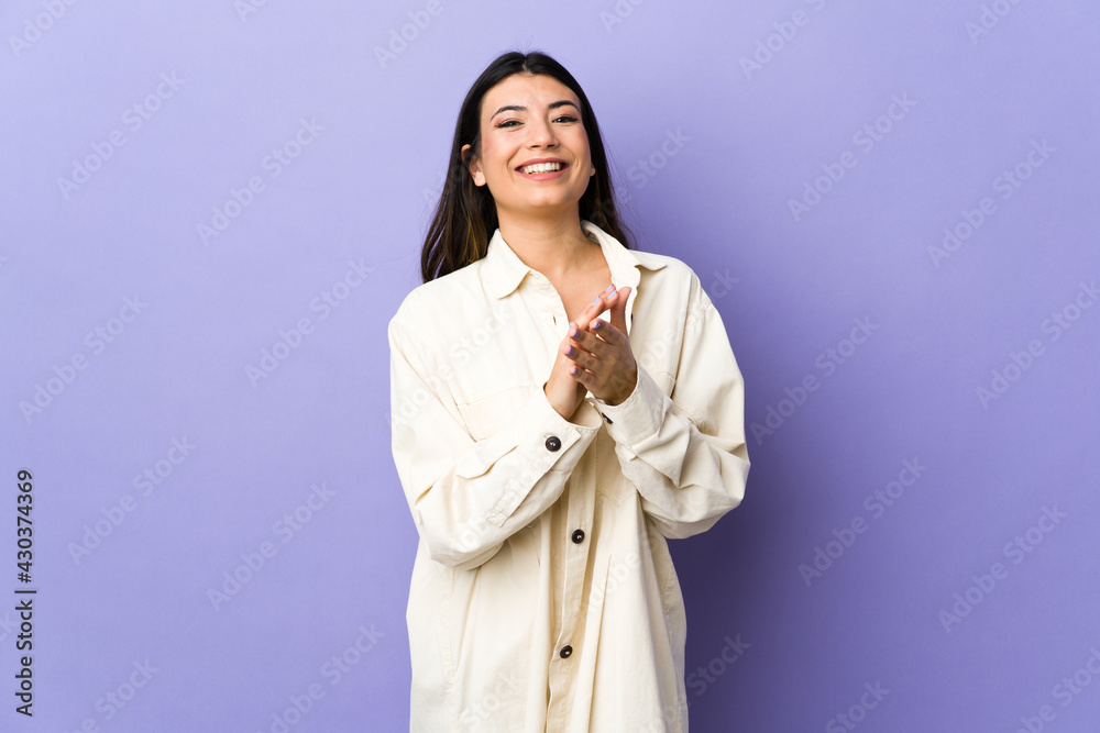 Young brunette woman over isolated purple background applauding after presentation in a conference Young brunette woman over isolated purple background applauding after presentation in a conference