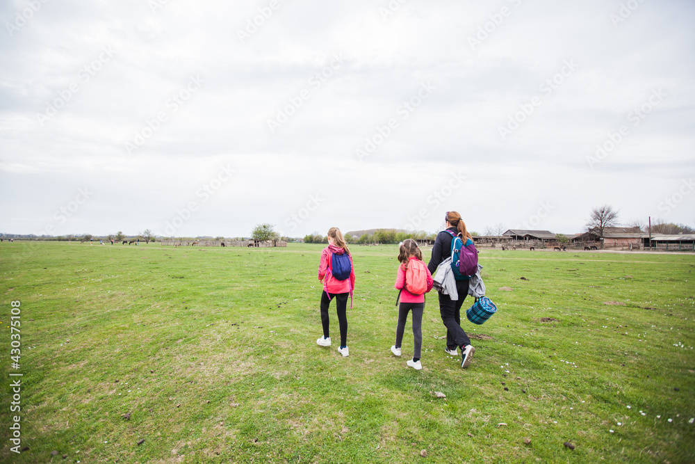 Family relax in nature reserve, mother with daughters walking in nature, spring landscape. Family relax in nature reserve, mother with daughters walking in nature, spring landscape.