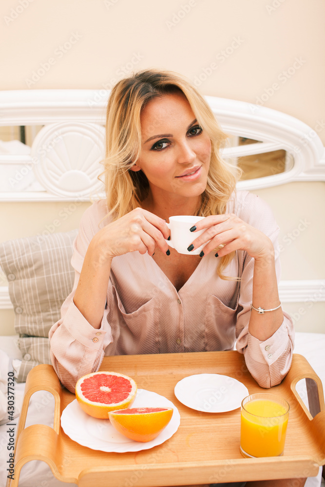 young beauty blond woman having breakfast in bed early sunny morning, princess house interior room, healthy lifestyle concept young beauty blond woman having breakfast in bed early sunny morning, princess house interior room, healthy lifestyle concept