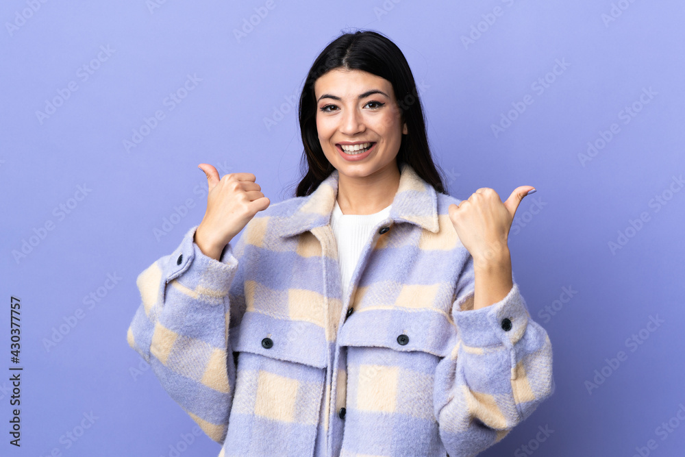 Young brunette woman over isolated purple background with thumbs up gesture and smiling Young brunette woman over isolated purple background with thumbs up gesture and smiling